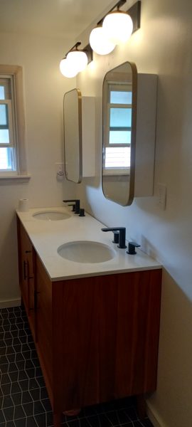 Finished modern bathroom with double vanity and globe lights