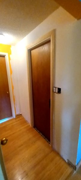 Hallway with old orange paint partially covered