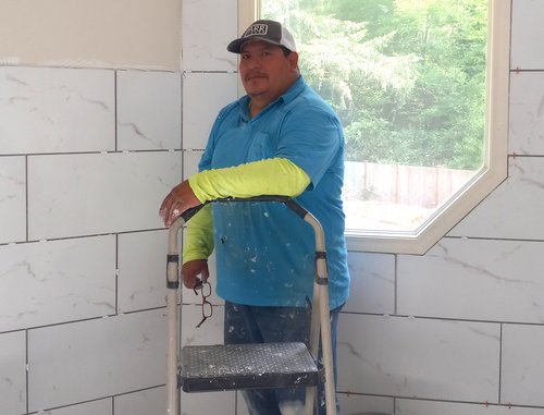 Mario, owner of Abigail and Mario Handyman, on a job site with his tile work