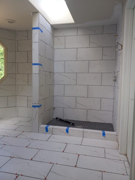 Completed marble tile shower installation with smooth finished walls