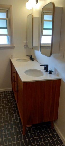 Finished bathroom remodel with double vanity, modern mirrors, and dark geometric floor tile